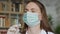 Female doctor with a medical mask and protective gloves holding syringe with medicine.