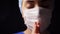 Female doctor or nurse in face mask praying