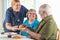 Female Doctor or Nurse Serving Senior Adult Couple Sandwiches at