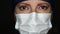 Female Doctor or Nurse Wearing Surgical Medical Face Mask and Cap Looking Into The Camera