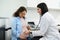 Female doctor obstetrician gynecologist checks heartbeat of the baby in womb using stethoscope. Gynecology consultation.