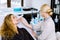 Female doctor and patient during examination of facial skin. The results of the skin condition are shown on the display.