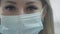 The female doctor puts on a blue medical protective mask. Protects itself from viruses during a coronavirus pandemic. A