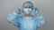 Female doctor puts on medical cap before surgical treatment in clinic. Portrait of woman in medical uniform, protection mask and l