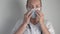 A female doctor puts a protective medical mask on her face.