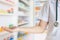 Female doctor with shelves filled with medication