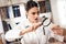 Female doctor sitting at desk in office with microscope and stethoscope. Woman is looking at donut with magnifyer.