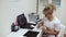 Female doctor sitting at the table and writing on electrocardiogram results.