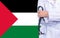 Female doctor with stethoscope in hand on the background of the Palestine flag. Concept medicine, pandemic in the country