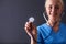 Female doctor with a stethoscope listening, isolated on gray background