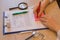 Female doctor with stethoscope sitting at a desk, writing something, prescription or recommendation of the patient, the photo