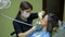 Female doctor stomatologist at work treats and whitens teeth to young woman patient in medical dental clinic