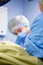 Female Doctor in Surgery Operating Hospital Room. Surgeon medic in protective work wear gloves, mask and cap