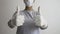 A female doctor with a surgical mask and rubber gloves gives thumbs up with both hands