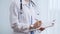 Female doctor taking notes on clipboard. Close-up of a unrecognizable female healthcare professional writing and filling