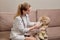 A female doctor is trying to check a child hearing with an otoscope.