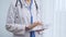 Female doctor using digital tablet in clinic. Healthcare professional with a stethoscope around her neck operating a