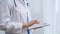 Female doctor using digital tablet in clinic. Healthcare professional with a stethoscope around her neck operating a