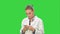 Female doctor using texting messages using modern smartphone and smiling on a Green Screen, Chroma Key.