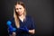 Female doctor wearing scrubs looking confused holding telephone