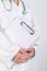 Female doctor in white uniform posing with blank clipboard pad