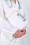 Female doctor in white uniform posing with blank clipboard pad