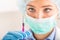 Female doctor working with syringe needle and ampoule of medicine. A scientist in sterile clothes is making a vaccine drug