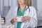 a female doctor and a young nurse keep cups of coffee in hands and gossip with each other during coffee break in the staff room