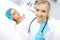 Female doctor and young woman patient in hospital. Physicians examine girl lying at the bed, view from above