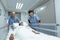 Female doctors pushing emergency stretcher bed in corridor