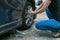 Female driver changing tyre on her broken car.