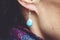 Female ear wearing elegant silver gemstone earring