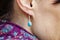 Female ear wearing elegant silver gemstone earring