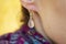 Female ear wearing elegant silver gemstone earring