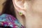 Female ear wearing elegant silver gemstone earring