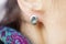 Female ear wearing elegant silver gemstone earring