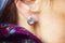 Female ear wearing elegant silver gemstone earring