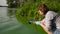 Female ecologist takes samples of river water infected with green algae in tube