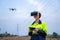 A female electrical engineer wearing vr goggles flying drone to explore aerial view equipment on high voltage pylons at power