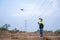 A female electrical engineer wearing vr goggles using drone to fly inspect power station in aerial view to plan, develop or