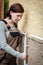 female electrician installs cable outside on a house wall