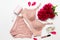 Female elegant pink lace bra, flat peony, lipstick, hand cream and barrette on a white background, flat lay