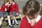 Female Elementary School Pupils Whispering In Playground