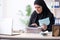 The female employee bookkeeper in hijab working in the office