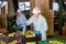 Female employee of fruit warehouse in uniform labeling fresh ripe apples in crates