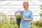 Female Employee At Garden Center Holding Lavender Plant In Green