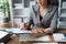 female employee holds a pen and checks investment financial documents.