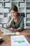 female employee holds a pen and checks investment financial documents.