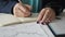 Female employee making notes with pen sitting at table in office.