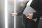 Female employee pressing the elevator button and holding the laptop. Businesswoman in the formal black suit is pushing the button